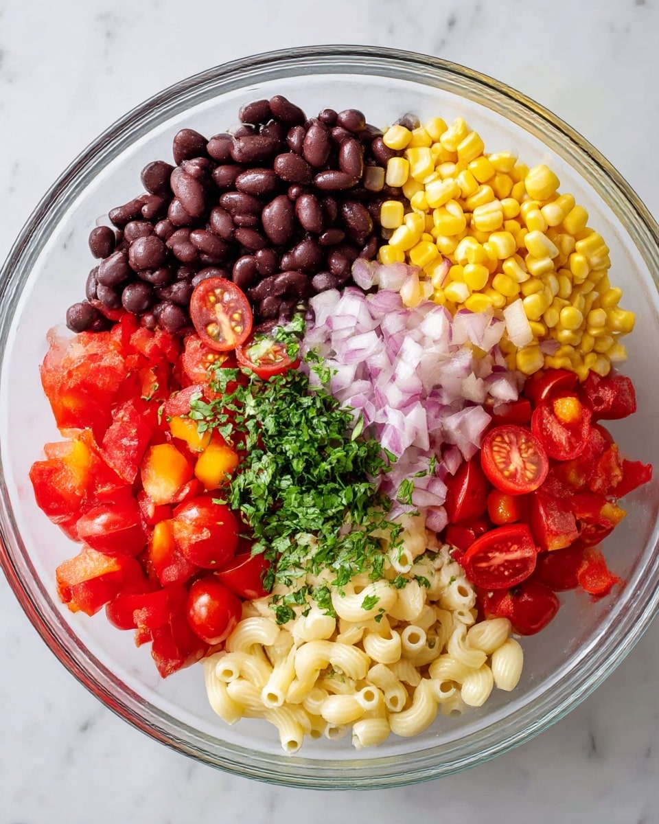 A clear glass bowl on a white marbled surface holds a colorful salad with six visible layers placed side by side in sections. Starting from the top right, dark brown black beans with a few yellow corn kernels, below them bright yellow corn, next to the corn light pink chopped onions, then diced red bell peppers with some yellow corn mixed in, cherry tomatoes cut in halves with red skin and juicy red insides, and lastly cooked elbow macaroni with fresh chopped green herbs sprinkled over. The textures range from smooth beans to crisp peppers and juicy tomatoes. photo taken with an iphone --ar 4:5 --v 7