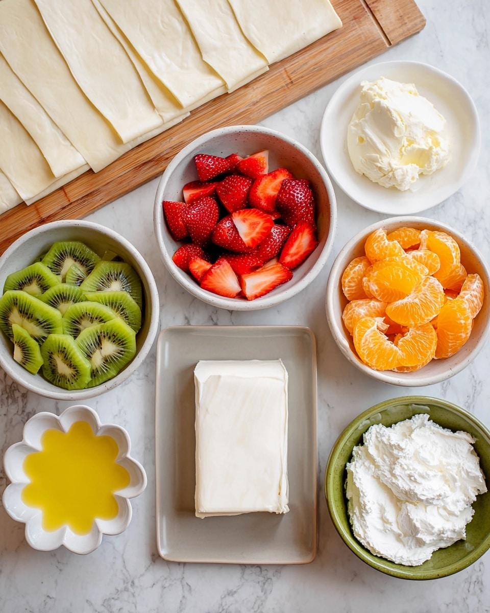 The image shows several white bowls and a plate on a white marbled surface, holding layers and ingredients for a fruit dessert. One bowl contains bright green sliced kiwis arranged in a circular pattern, another has red sliced strawberries with their pointed ends facing up, and a third bowl is filled with bright orange peeled mandarin segments. A small flower-shaped white dish holds a yellow liquid, likely melted butter. A grayish-white plate holds a rectangular block of cream cheese with a smooth texture. Another green bowl contains a fluffy, white, creamy mixture. In the background, a wooden cutting board holds multiple thin, pale sheets of dough stacked neatly. Photo taken with an iphone --ar 4:5 --v 7